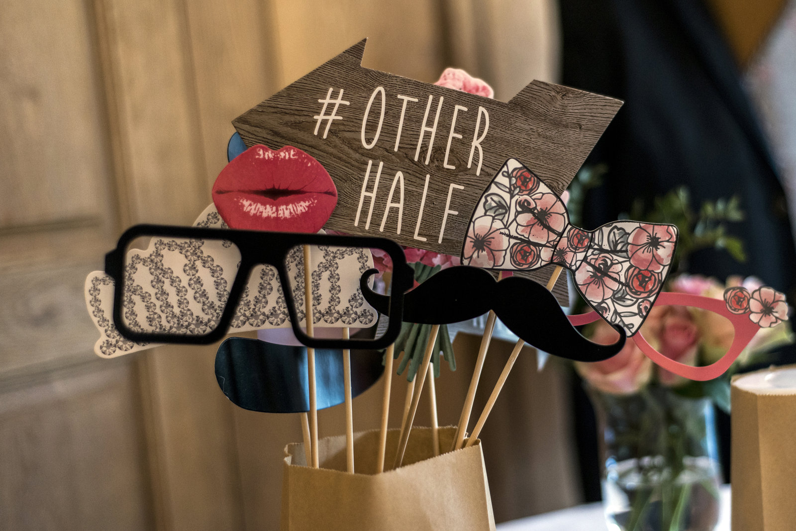 Photo booth props including lips, glasses, a mustache, and an Other Half sign